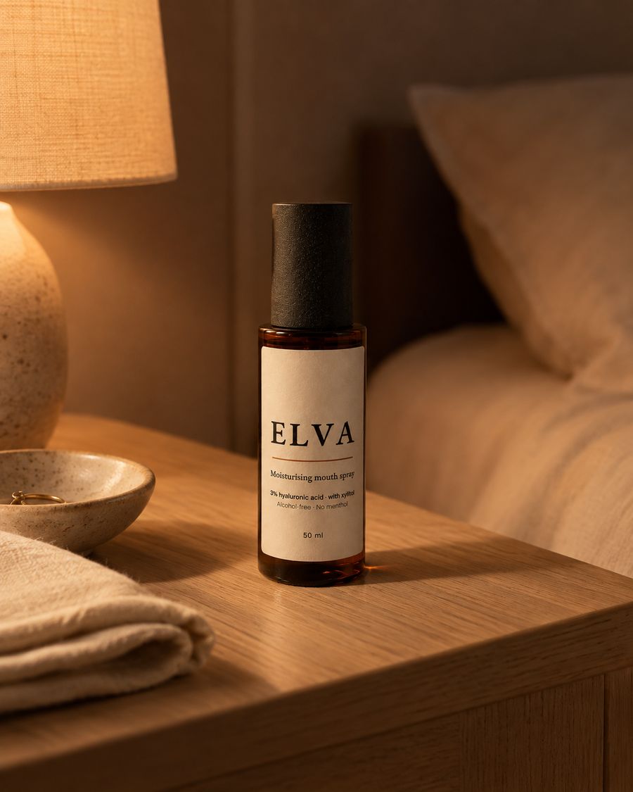 ELVA on a bedside table at night, next to a lit lamp